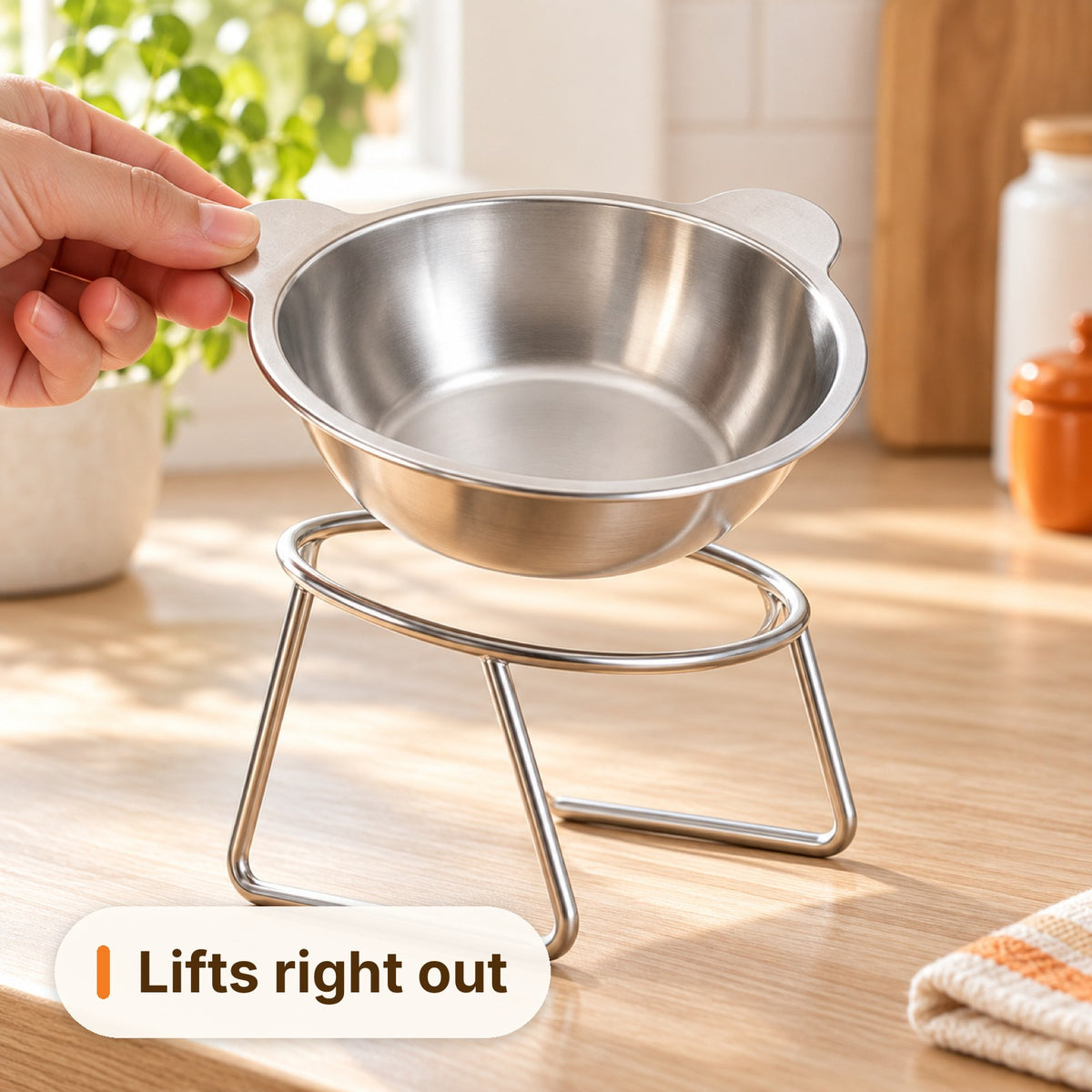 Hand lifting the stainless steel bowl out of its stand